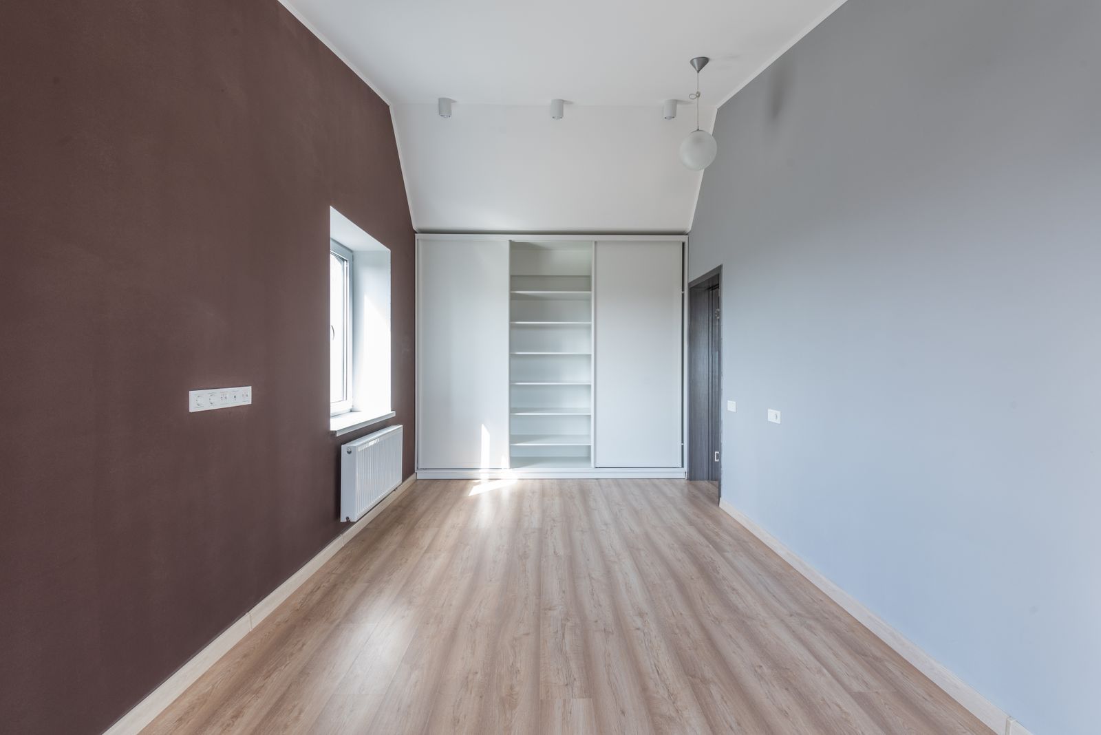 Stanza vuota con pavimento effetto legno e luce naturale